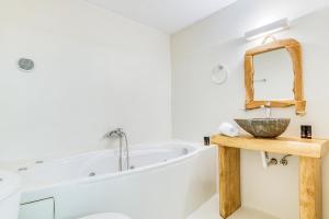 een badkamer met een bad, een wastafel en een spiegel bij Casa Lina large central apartment, beach access in Kampos Paros +11 foto's