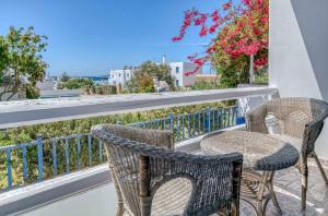 twee stoelen en een tafel op een balkon bij Casa Lina large central apartment, beach access in Kampos Paros