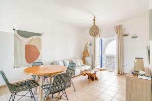 een woonkamer met een tafel, stoelen en een bank bij Casa Lina large central apartment, beach access in Kampos Paros