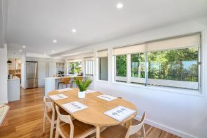 a kitchen and dining room with a table and chairs at Noosa Escape 2BR Ocean Views, Walk to Beach in Noosa Heads +20 photos