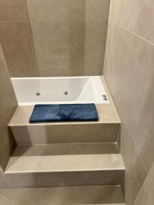 een badkuip met een blauwe zitting in een badkamer bij EUROPA Dúplex reformado en verano25 in Sierra Nevada