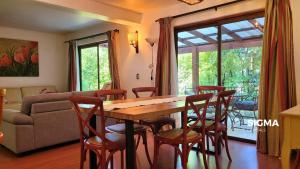 uma sala de estar com uma mesa e cadeiras de madeira em Amplia Casa Familiar en Condominio Privado em Pucón mais 10 fotografias