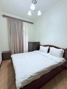 a bedroom with a large bed with white sheets at 2 Bedroom 2 bathroom Republic Square in Yerevan