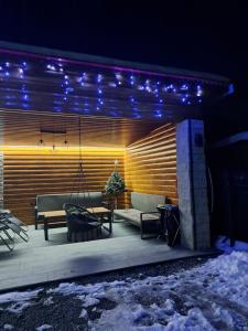 un patio con sofá, mesa y luces en Ubytovanie u Karasa, en Vitanová