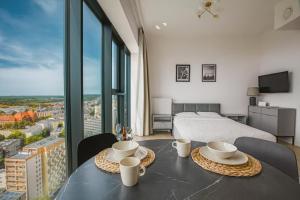 una camera da letto con un letto e un tavolo con due tazze di Luksusowy apartament z widokiem, basenem i sauną Hanza Tower a Stettino