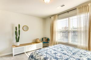 3 Mi to Lake Wylie! Modern Charlotte Townhome في Pine Harbor: غرفة نوم بسرير ونافذة فيها صبار