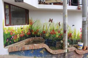 un mural de flores al lado de un edificio en El mirador Raquira centro, en Ráquira