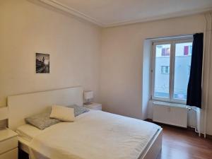 une chambre avec un lit blanc et une fenêtre dans l'établissement Geste Haus Luzern, à Root