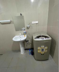 a small bathroom with a toilet and a sink at Moringa Villa in Maruthanamadam +2 photos
