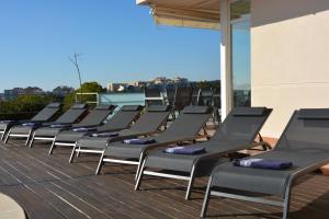 una fila di sedie a sdraio sedute su un tetto di Villa Med A 2 kilometros andando de la playa, del puerto de Aguadoç y a 4 del centro de Sitges Muy Soleada todo el dia Capacidad superior a 16 personas NO REQUIERE COCHE a Sitges