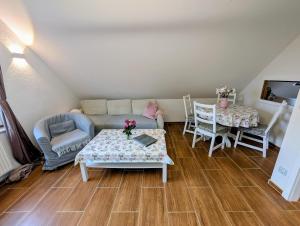 a living room with a couch and a table and chairs at Gemütliche 2-Zimmer-Ferienwohnung mit Garten in Mittenwalde