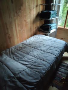 una cama sentada en una habitación junto a una ventana en Cabañas mountain Native forest, en Voipire