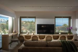 a living room with a couch and a flat screen tv at Villa Alquimia Aa with private Swimming pool in Hersonissos