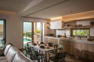 a kitchen and dining room with a table and chairs at Villa Alquimia Aa with private Swimming pool in Hersonissos