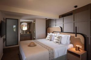 a bedroom with a white bed with a hat on it at Villa Alquimia Aa with private Swimming pool in Hersonissos +12 photos