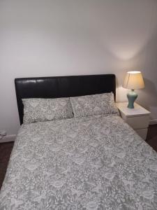a bedroom with a large bed with a black headboard at Christian Guest House 1 in Luton