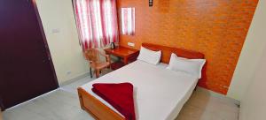 En eller flere senge i et værelse på KSR Aura Homestay