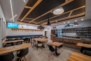 Un restaurante con mesas y sillas de madera y un bar. en Dovalovec Resort, en Liptovský Hrádok