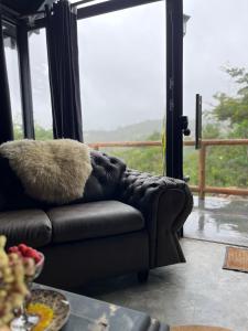 um sofá com uma almofada felpuda em frente a uma janela em ConstelacaodaChapada em Ibicoara