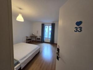 une chambre avec un lit et une pièce avec un cœur sur le mur dans l'établissement Geste Haus Luzern, à Root 7 autres photos