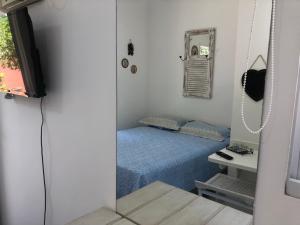 una piccola camera da letto con un letto e uno specchio di Espaço mel a Búzios