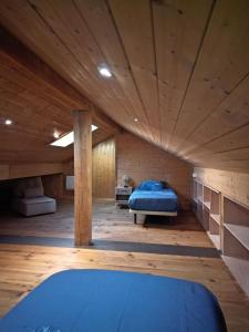 a large room with a bed in a wooden ceiling at Chalet EGAT in Égat