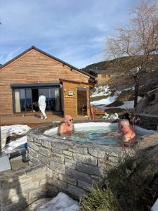 two men in a jacuzzi in a stone wall at Chalet EGAT in Égat +39 photos