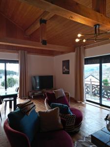 a living room with a couch and chairs and a television at Chalet EGAT in Égat