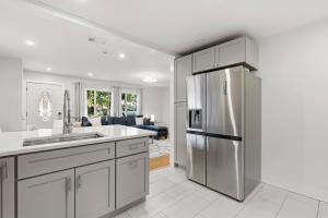 Una cocina con refrigerador de acero inoxidable y una sala de estar. en Happy Ours, en New Smyrna Beach