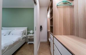 Thea- Duomo Centro storico في مونزا: غرفة نوم بسرير وخزانة