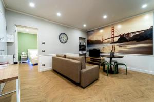 Thea- Duomo Centro storico في مونزا: غرفة معيشة مع أريكة وساعة على الحائط