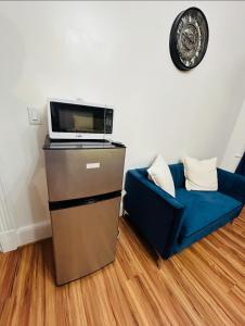 a living room with a microwave and a blue couch at Big Mama's House in Paterson +10 photos
