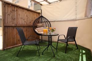 a patio with a table and chairs on the grass at Melony Tsfat in Safed