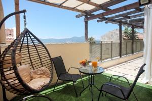 a patio with a hammock and a table and chairs at Melony Tsfat in Safed