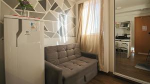 ein Wohnzimmer mit Sofa und eine Küche in der Unterkunft Flat com Piscina, Academia e Sauna em Aguas Claras in Águas Claras