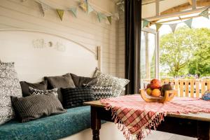 a room with a couch and a bowl of fruit on a table at Burren Glamping in Kilfenora