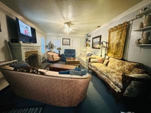 a living room with a couch and a tv at 1 mile to Fort Sill! The CaroleBelle Cottage sleeps 8 with hottub,grills,firepit in Lawton