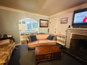 a living room with a couch and a flat screen tv at 1 mile to Fort Sill! The CaroleBelle Cottage sleeps 8 with hottub,grills,firepit in Lawton