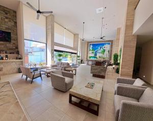 Grand Fifty Suites في بلايا ديل كارمن: غرفة معيشة كبيرة مع أرائك وتلفزيون