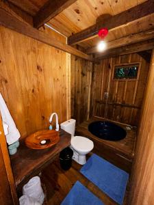 a wooden bathroom with a toilet and a sink at Pousada Quintal Verde in Guabiruba +54 photos