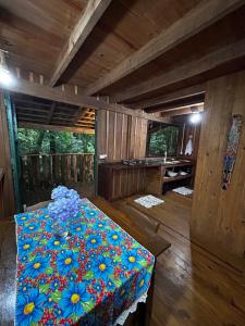 a room with a table with flowers on it at Pousada Quintal Verde in Guabiruba
