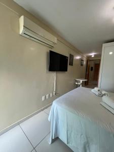 una camera con letto bianco e TV a schermo piatto di ISRAEL FLAT TAMBAÚ - 102 a João Pessoa