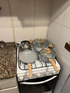 a stove with three pots and pans on it at Capibara 7 - Alborada in Corrientes +3 photos