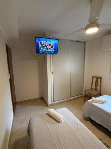 a room with two beds and a tv on the wall at Capibara 7 - Alborada in Corrientes