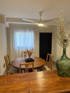 a dining room table with a vase on top of a table at Capibara 7 - Alborada in Corrientes
