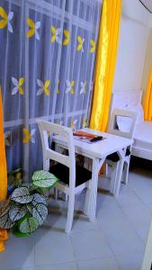 a white table and two chairs in a room at Phee home in Mombasa