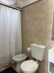 Un baño con un inodoro blanco y un lavabo. en Loft - Zona hospitales - Familias!, en Rosario 14 fotos más