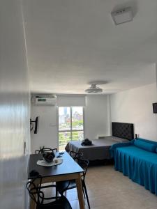 Una sala de estar con una cama, una mesa y sillas. en Loft - Zona hospitales - Familias!, en Rosario