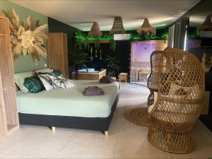 a bedroom with a bed and a chair in it at gîte romantique in Etalondes-la-Pipe