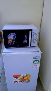 a microwave sitting on top of a refrigerator at Phee home in Mombasa